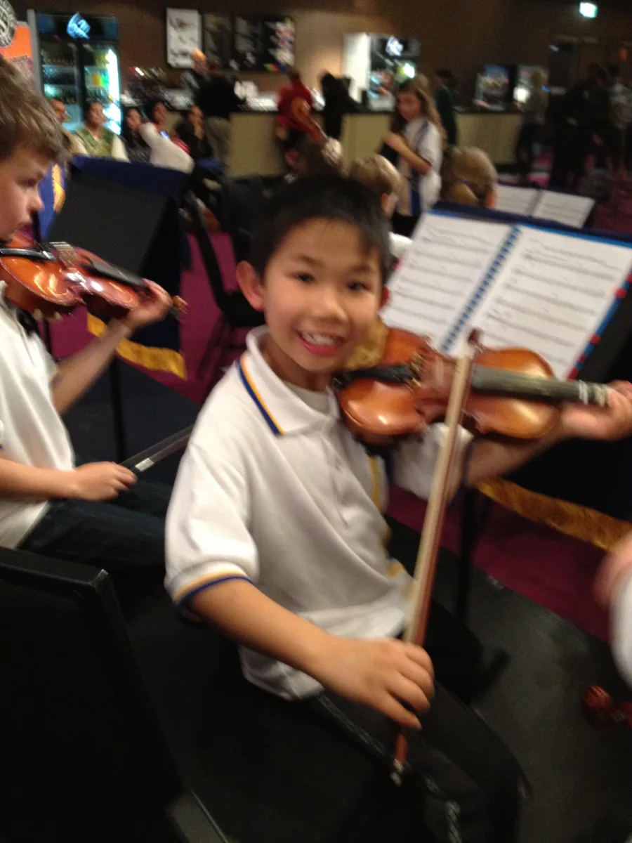 Young Anson holding a violin before a performance
